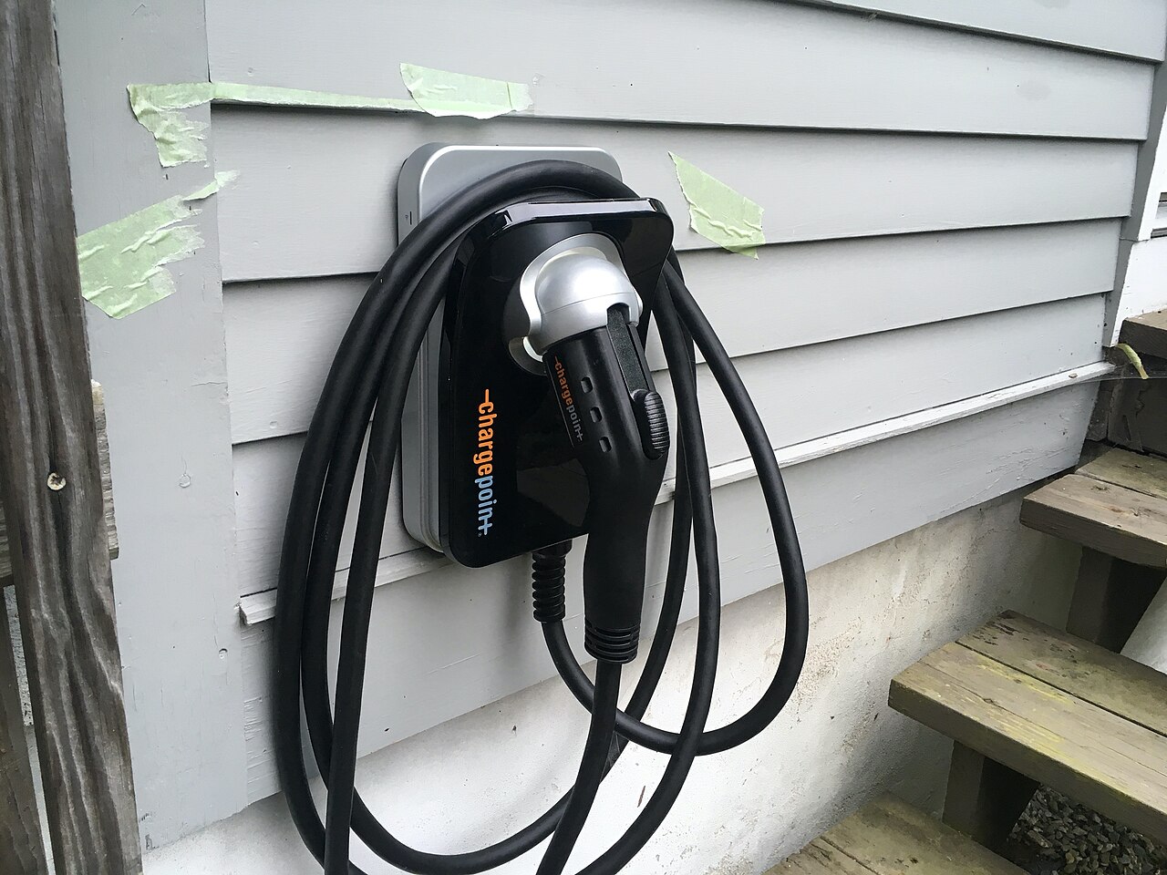 Level 2 EV charger wall-mounted at a home exterior with holstered cable — Bano Electrical Services Ltd